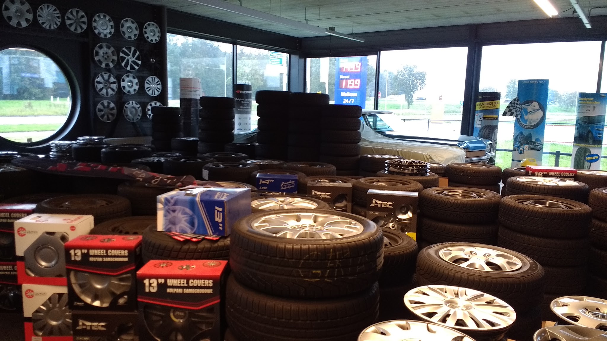 Showroom met banden en een velgenwand bij de grote ramen
